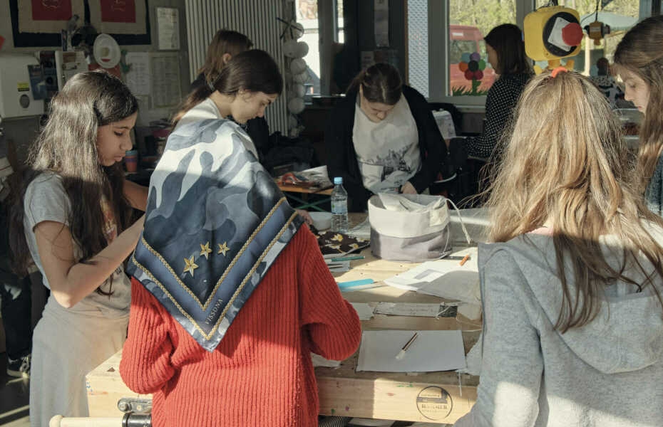 Schülerinnen arbeiten stehend am Tisch an einem Projekt