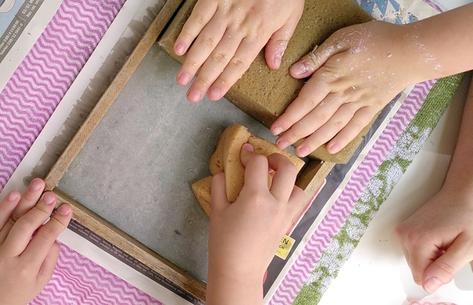 Kinderhände beim Papierschöpfen